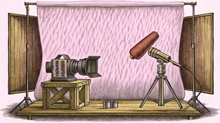 A studio camera and boom microphone rest on a metal workbench.