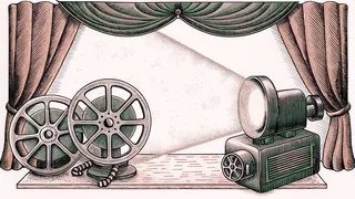 A film reel and projector rest beside a spotlight on a workbench.